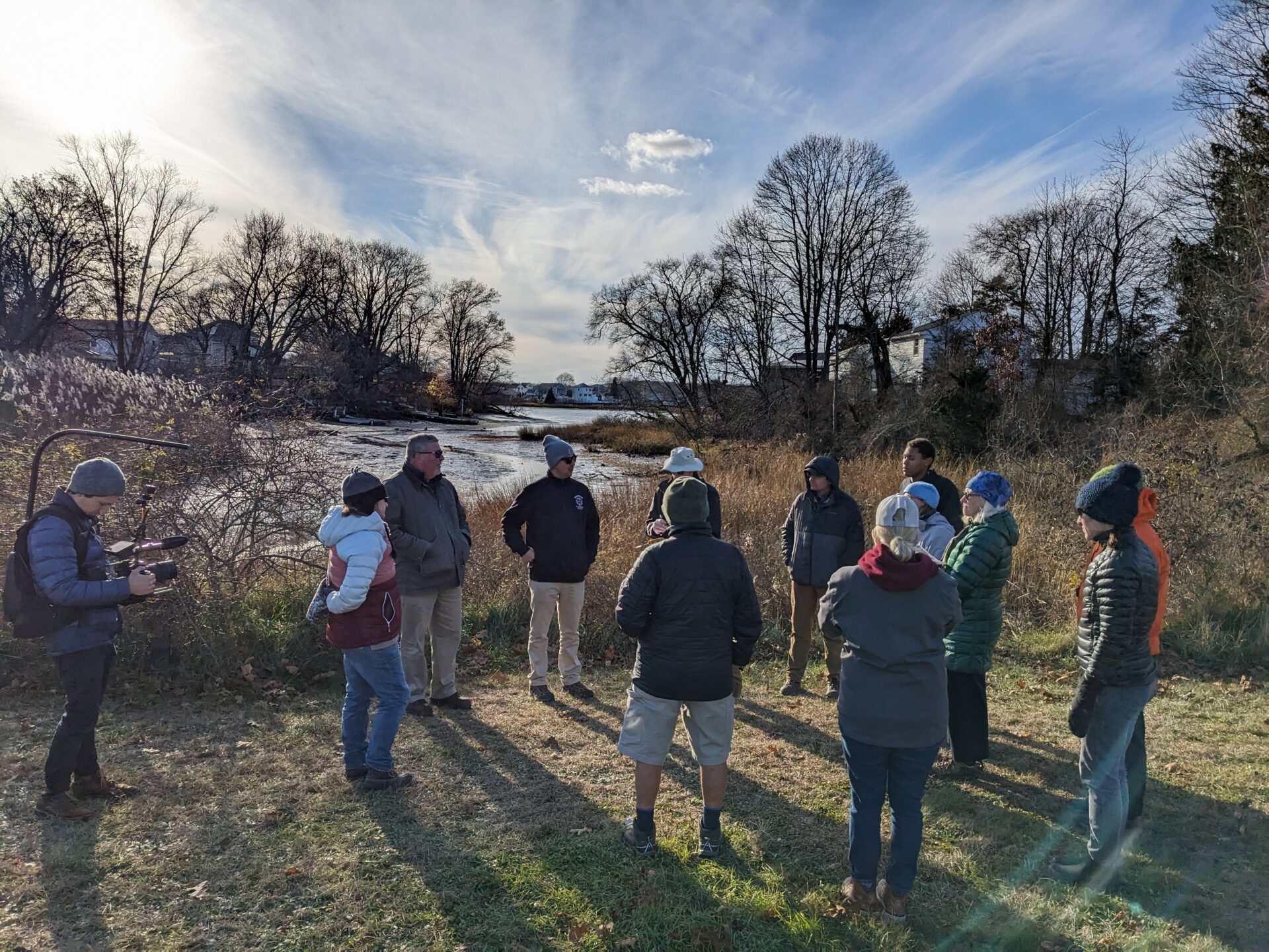 Group of people in cold weather clothing looking at a marsh